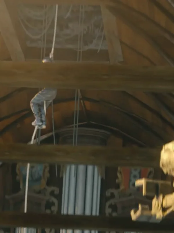 Cinematic film still — worker climbing scaffold